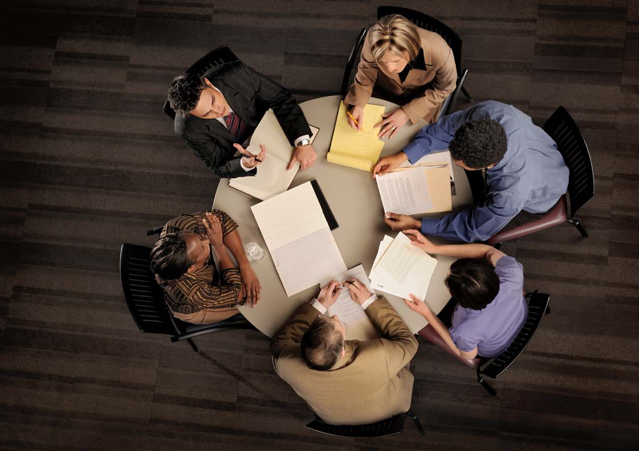 group of confident professional employees in a serious meeting from above